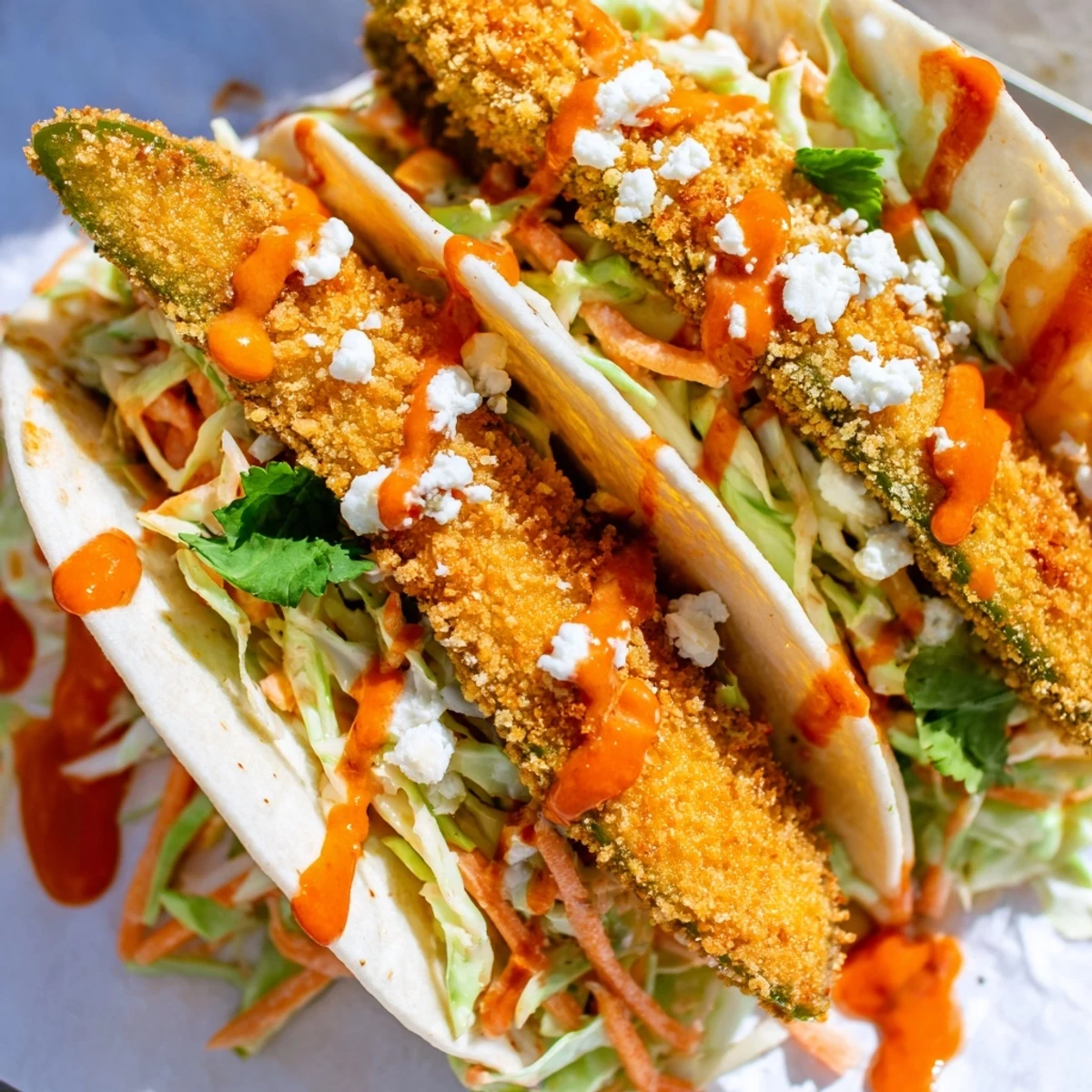 Savory Sweet Chili Fried Pickle Tacos topped with creamy slaw and crumbled feta.  