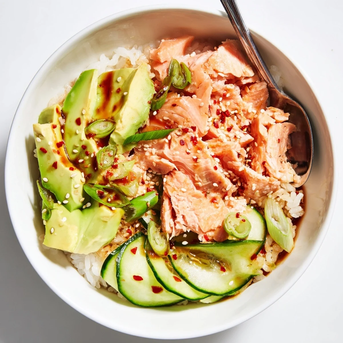 Leftover salmon and rice bowl garnished with fresh avocado and cucumber slices.