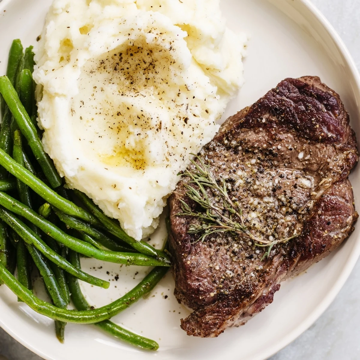 Roasted green beans and tender steak with creamy garlic mash, a delicious and easy sheet pan recipe.