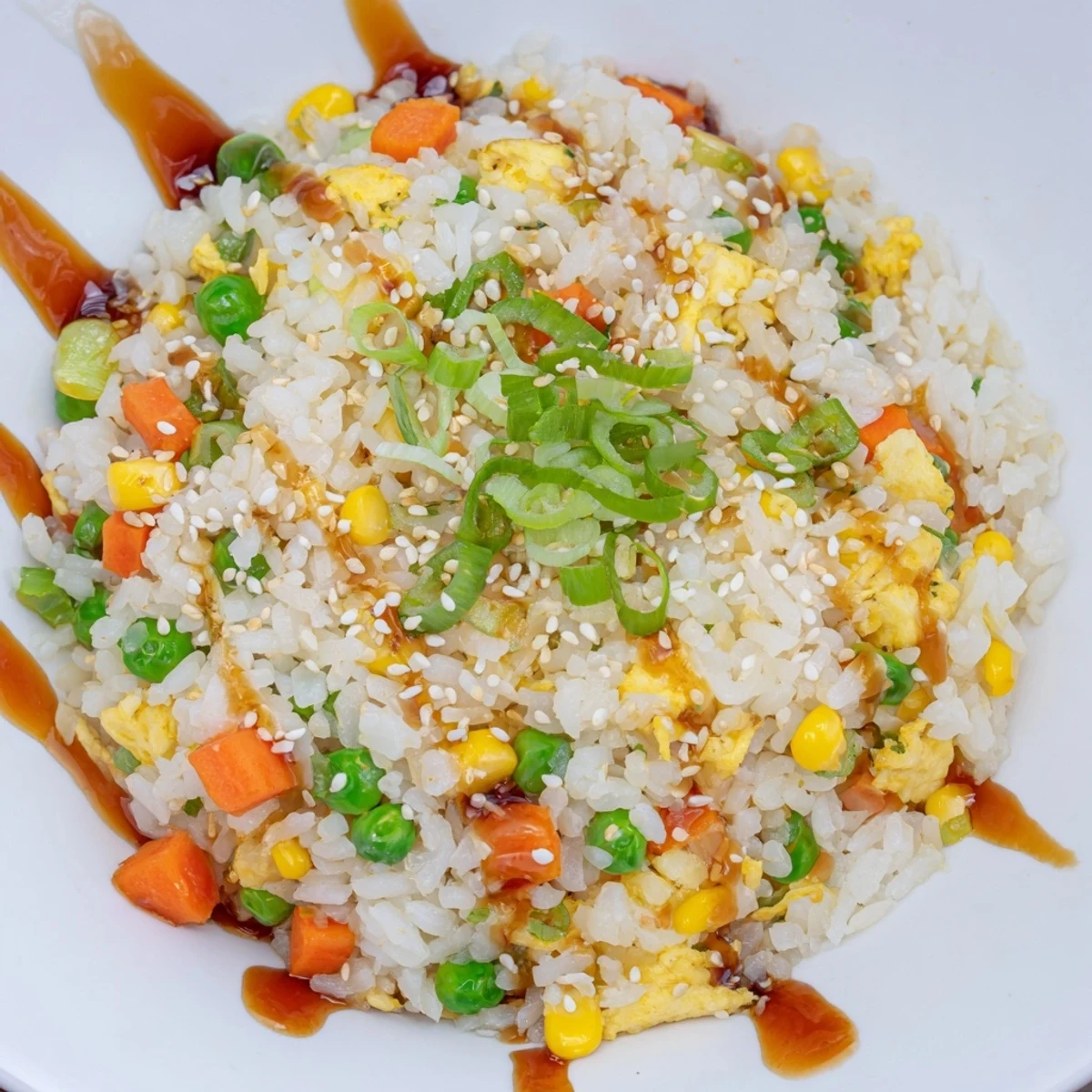 Close-up of fluffy Frozen Veggie Fried Rice featuring colorful vegetables, soy sauce, and delicate scrambled egg.
