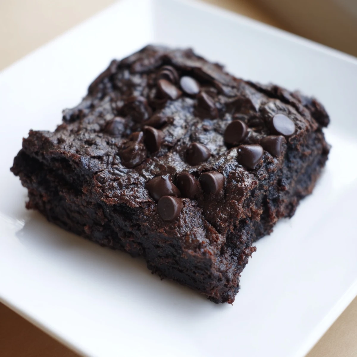 Warm, fudgy Black Bean Brownies, topped with melted chocolate chips, a delicious gluten-free dessert option.