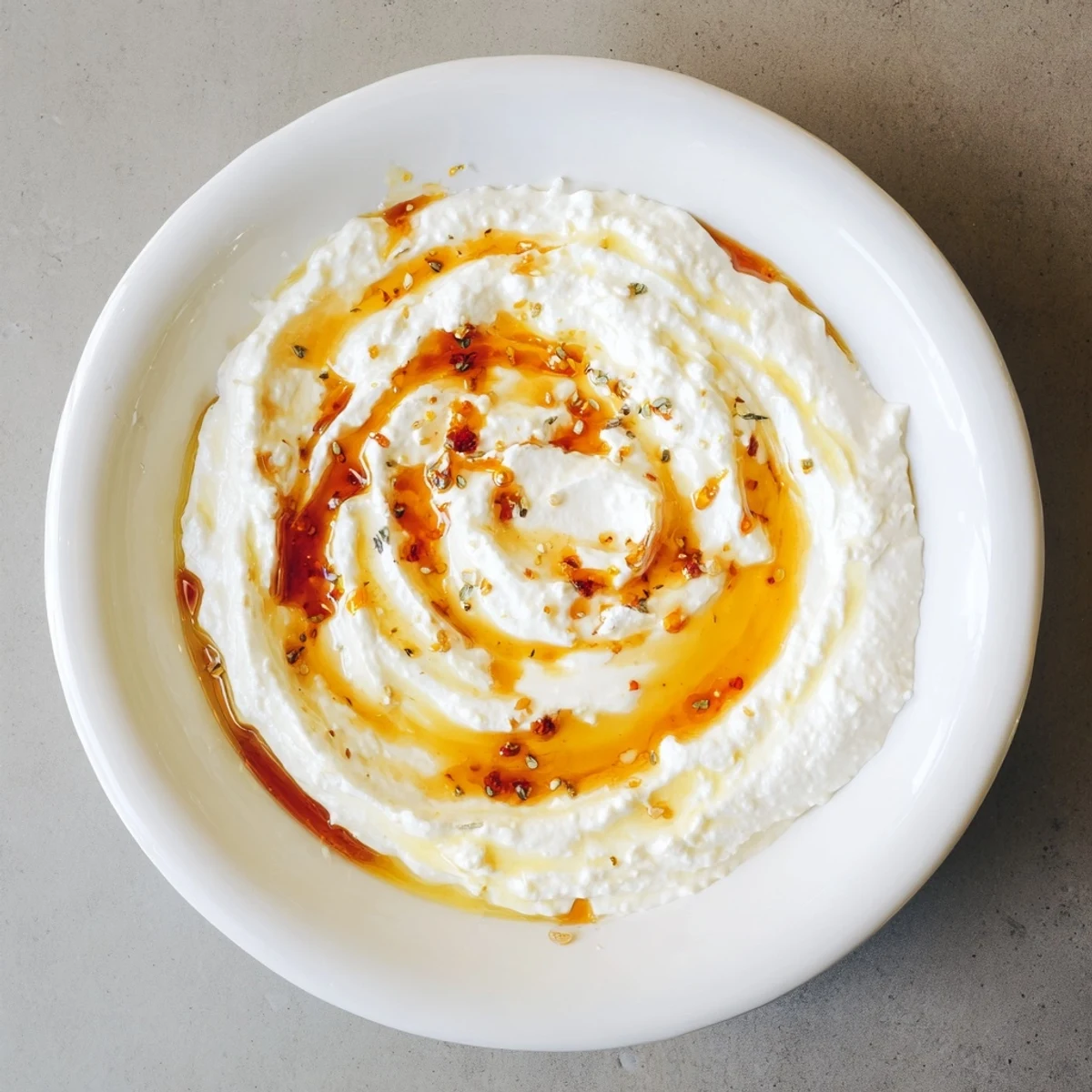 Creamy whipped ricotta dip with hot honey, drizzled and swirled for a spicy, sweet appetizer.