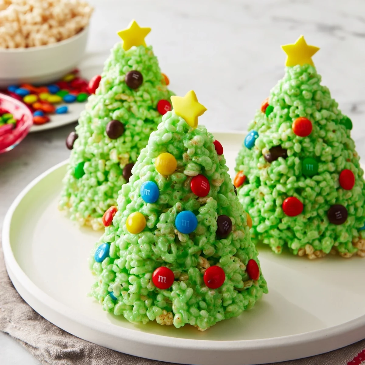 Festive green Christmas Tree Rice Crispy Treats topped with colorful candy decorations, delicious and sweet.