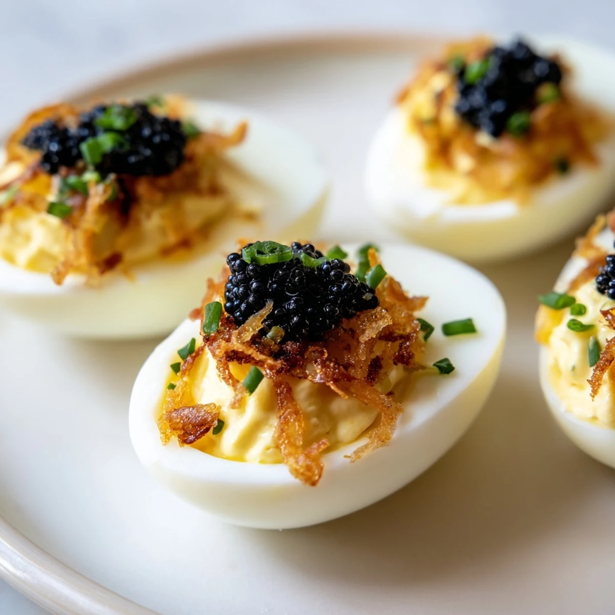 Creamy deviled eggs, delicately piped, showcase rich caviar and crispy shallot garnish for serving.