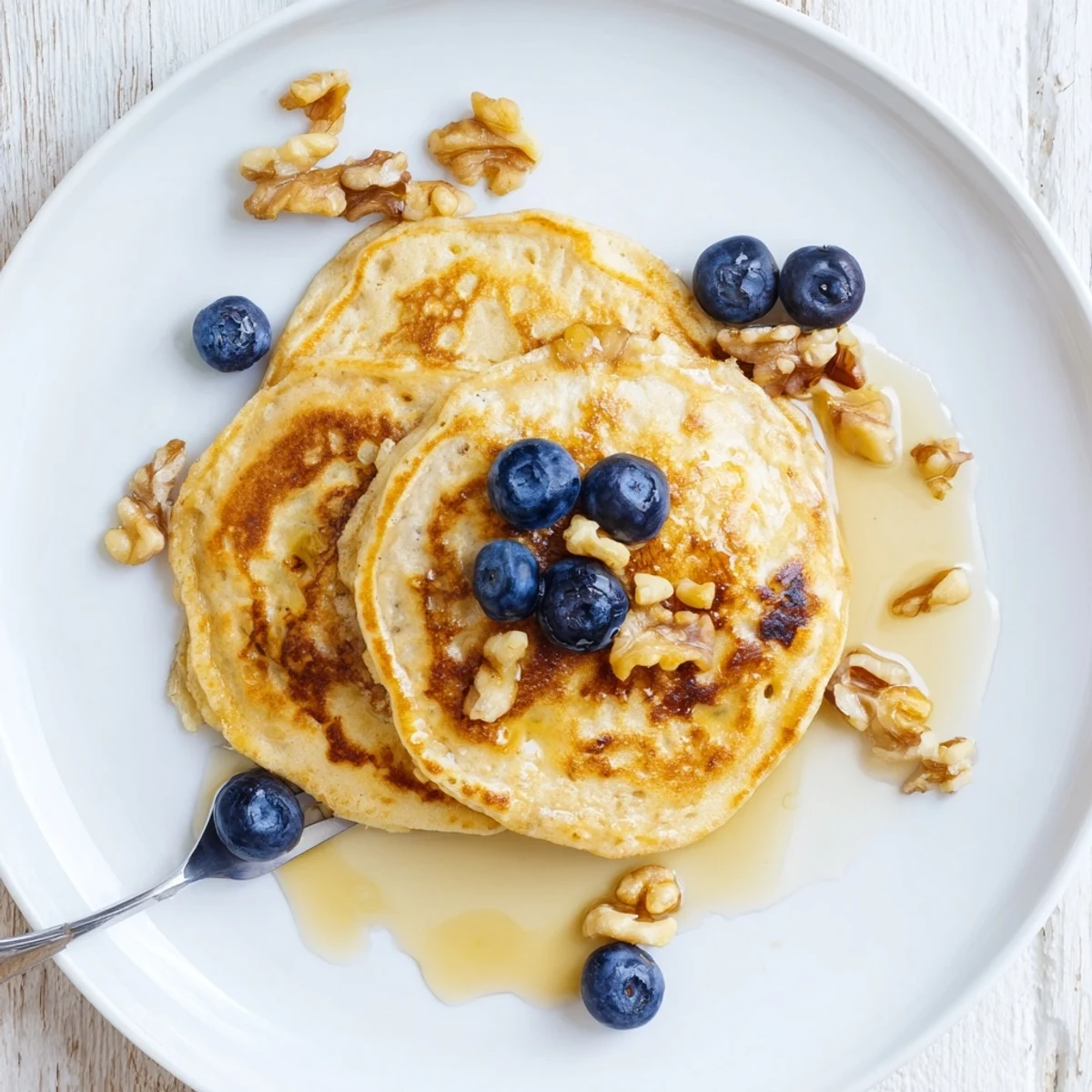 Fluffy brown banana pancakes, lightly speckled with banana, served warm and inviting on a plate.