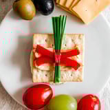 Delicious Graduation Cap Platter: A vibrant display with cheddar, olives, and grapes, perfect for any celebration.