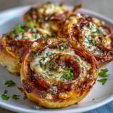 Golden-baked pizza pinwheels filled with gooey cheese, marinara sauce, and pepperoni slices—great appetizer or snack.  