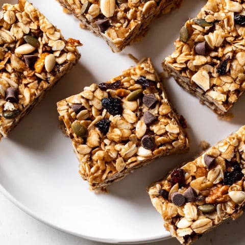 Golden-brown homemade granola bars, chewy and loaded with nuts and chocolate chips, ready to eat.