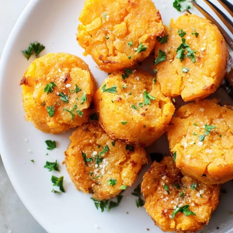Close-up of crispy Garlic Parmesan Sweet Potato Puffs, sprinkled with parsley, a delightful appetizer.