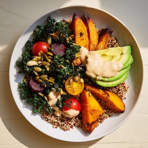 A creamy tahini dressing glistens over this colorful Quinoa, Kale & Roasted Beet Bowl, ready to eat.