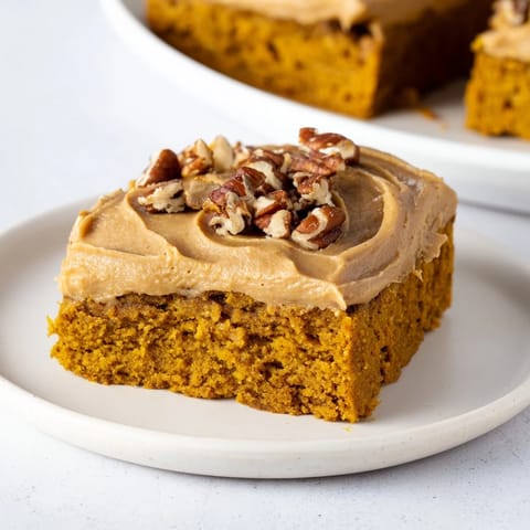 Golden Pumpkin Bars with brown sugar frosting, a decadent autumnal treat served on a plate.