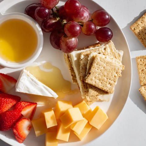 A beautifully arranged Bears Honey Pot Board, featuring fresh fruits, cheeses, crackers, and golden honey.