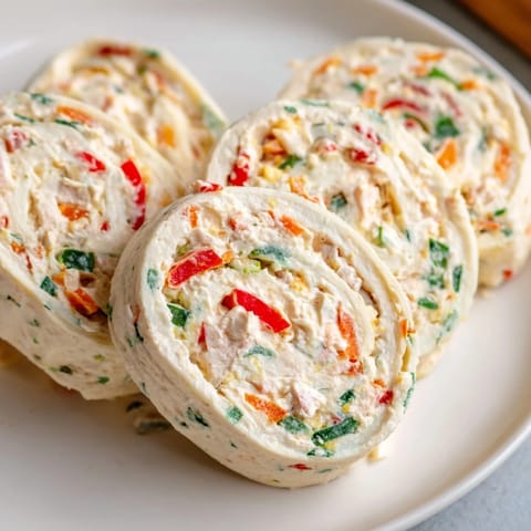 Close-up of vibrant Cozy Scarf Holiday Pinwheel Wraps; sliced, showing colorful filling, perfect for a party.