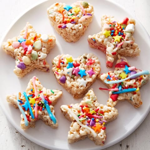 Warm, gooey Cookie Cutter Shaped Rice Krispies Treats, ready to be decorated and enjoyed as a fun snack.