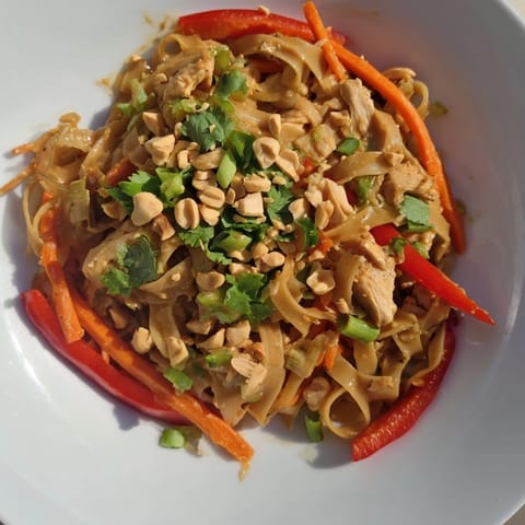 This flavorful Thai-Inspired Peanut Chicken Pasta salad showcases colorful vegetables with a creamy peanut dressing.