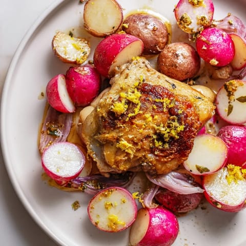 Juicy bone-in chicken thighs and sweet roasted radishes on a single sheet pan, garnished with fresh parsley.  
