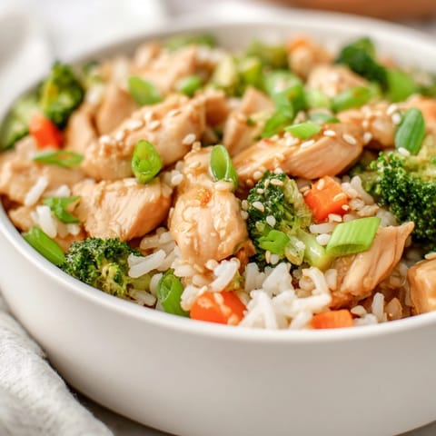Garnished with sesame seeds and green onions, One Pan Honey Garlic Chicken Broccoli Rice offers a savory and sweet aroma.