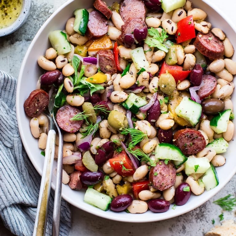 Anticipating flavors: Mediterranean Dense Bean Salad with salami featuring fresh herbs and a zesty dressing.