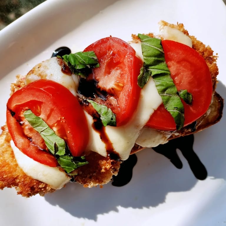 Crispy Chicken Caprese Sandwich served with a drizzle of balsamic glaze, highlighting the classic Italian-American flavors.