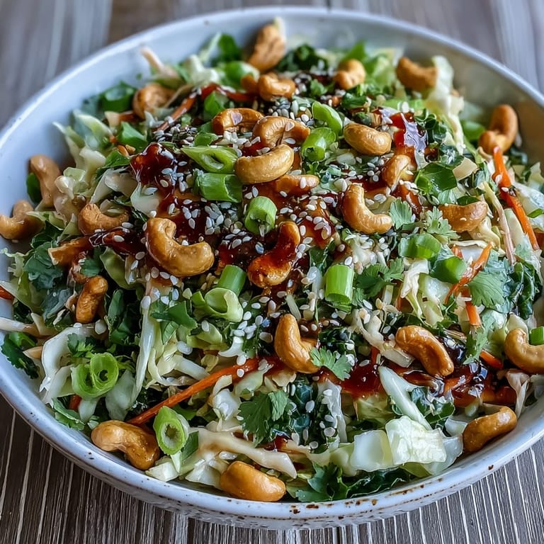 Crisp Asian Cabbage Salad topped with roasted cashews and sesame seeds, served as a refreshing vegan side for a summer cookout.